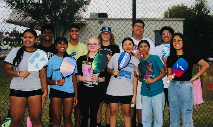 Group of youth holding pickleball paddles at fundraiser